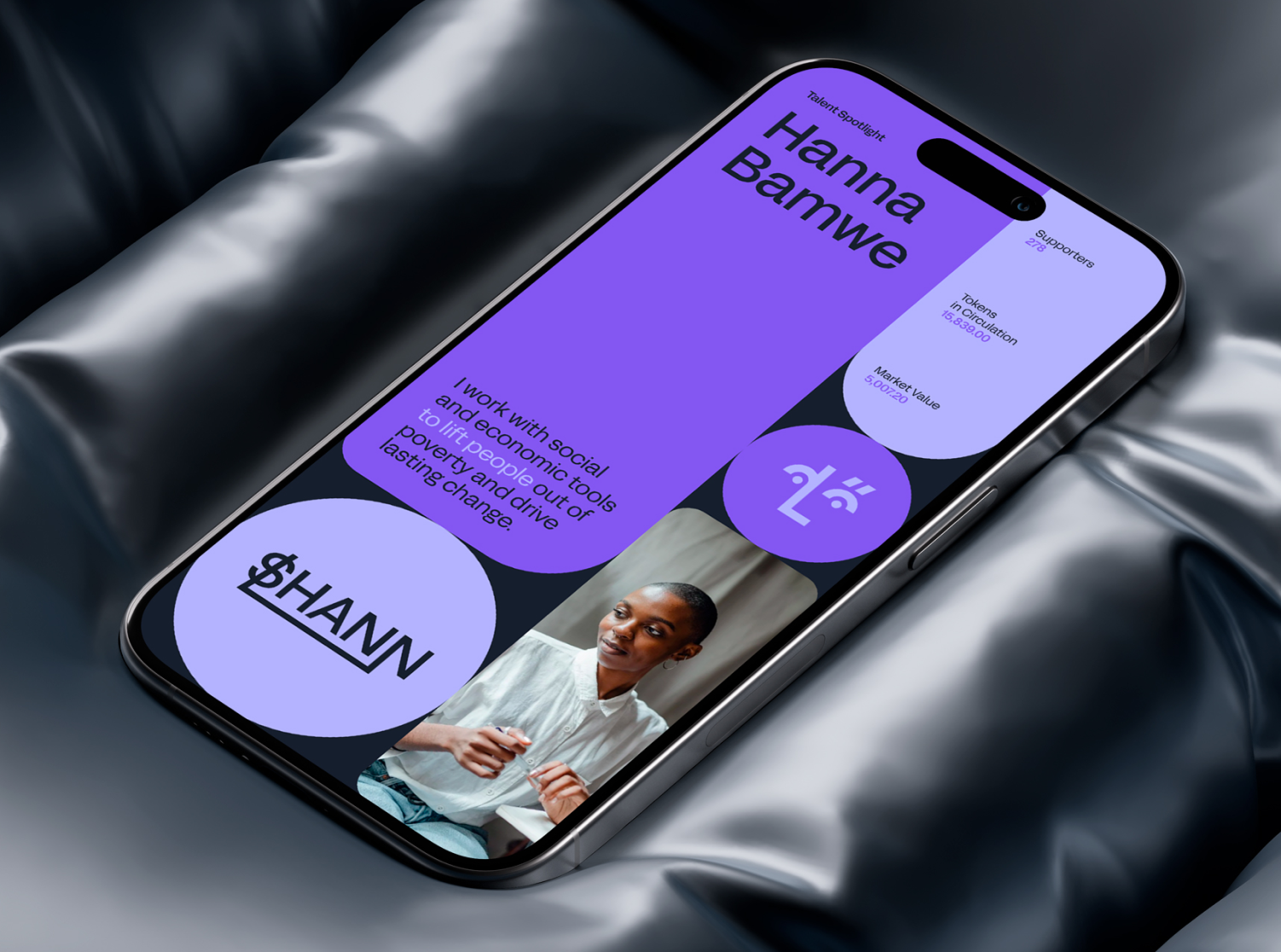 Smartphone screen featuring a profile for Hanna Bamwe. The screen has a purple theme and displays 'Talent Spotlight' at the top. Below, there is text that reads: 'I work with social and economic tools to lift people out of poverty and drive lasting change.' A circular icon with the text '$HANN' and a partially obscured photo of a person are visible. Additional details include: 'Supporters: 279', 'Tokens in Circulation: 8,888,000', and 'Market Value: $0.02'.